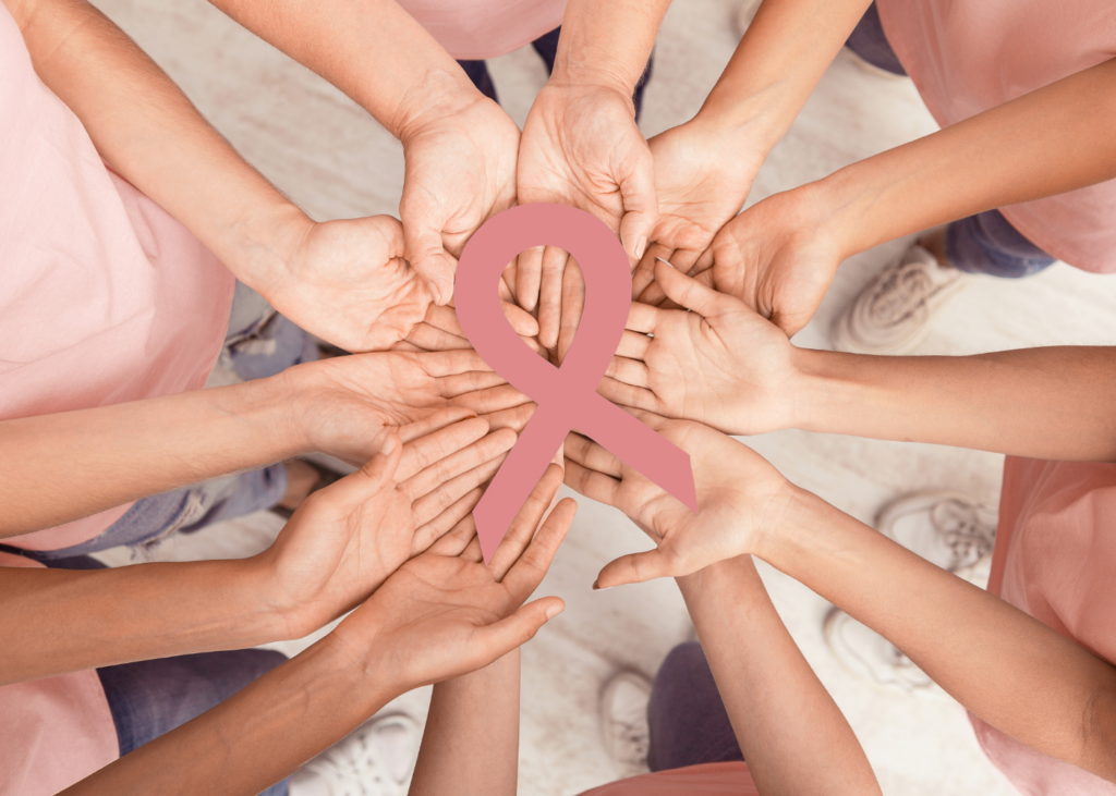 Mujeres sosteniendo un símbolo representativo del cáncer de mama